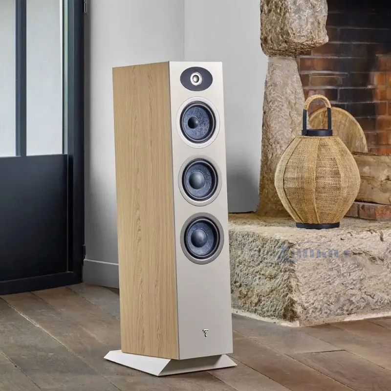 Loa Focal Theva N3-D Cận cảnh loa đứng Focal Theva N3-D với thiết kế gỗ tinh tế, ba củ loa lớn và một tweeter phía trên, đặt trong không gian phòng khách hiện đại cạnh lò sưởi.