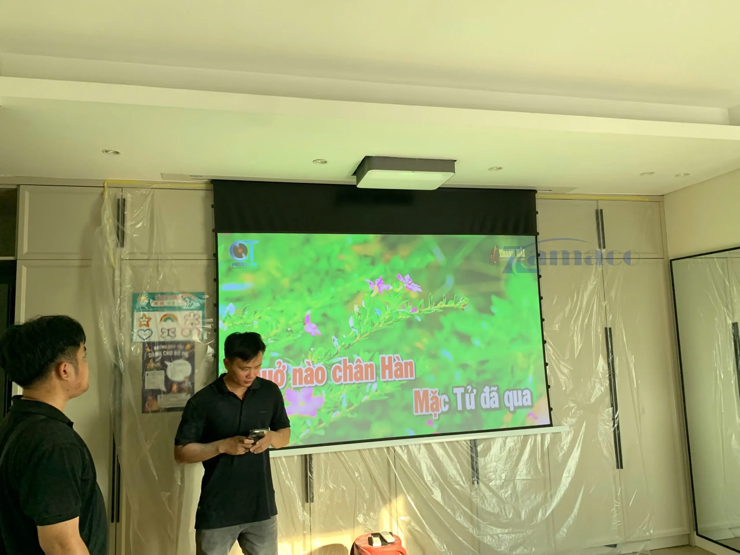 DỰ ÁN LẮP ĐẶT MÁY CHIẾU 4K LASER VAVA VA-LT002 VÀ MÀN CHIẾU ÂM TRẦN QUANG HỌC VIVIDSTORM VPCLALR100H 100 INCH Hệ thống máy chiếu laser VAVA VA-LT002 và màn chiếu âm trần quang học VIVIDSTORM 100 inch đang trình chiếu hình ảnh thực tế trong không gian phòng giải trí hiện đại.